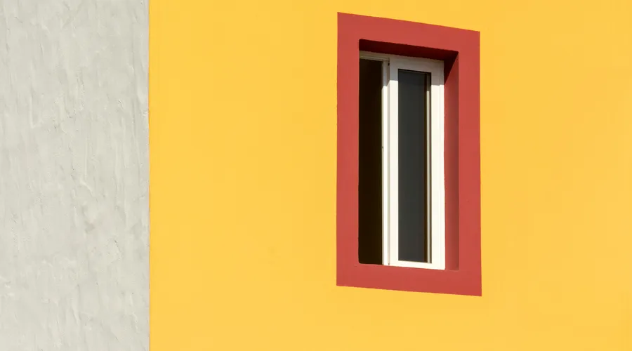 Which Should You Choose? - Geometric composition of a building's yellow facade with a red-framed window