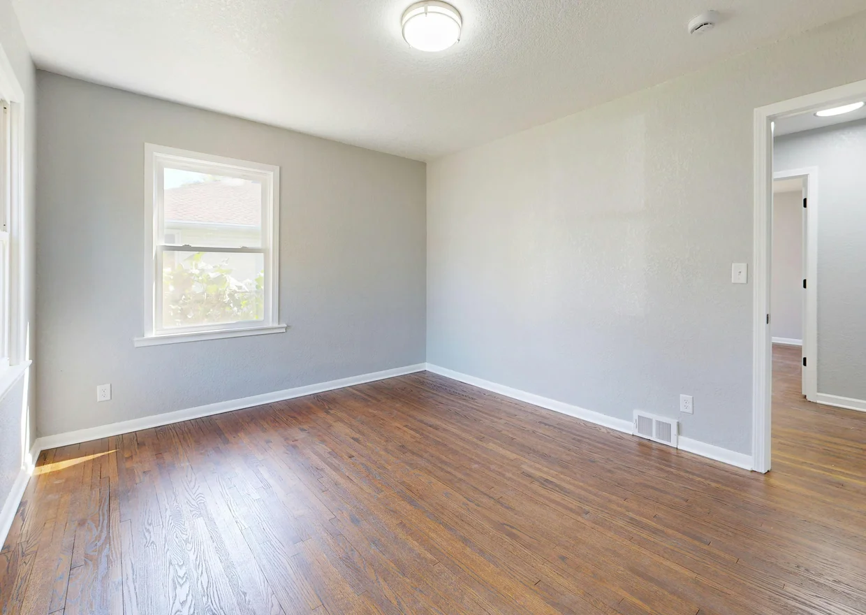 Spacious empty room featuring hardwood floors and natural light in Denver