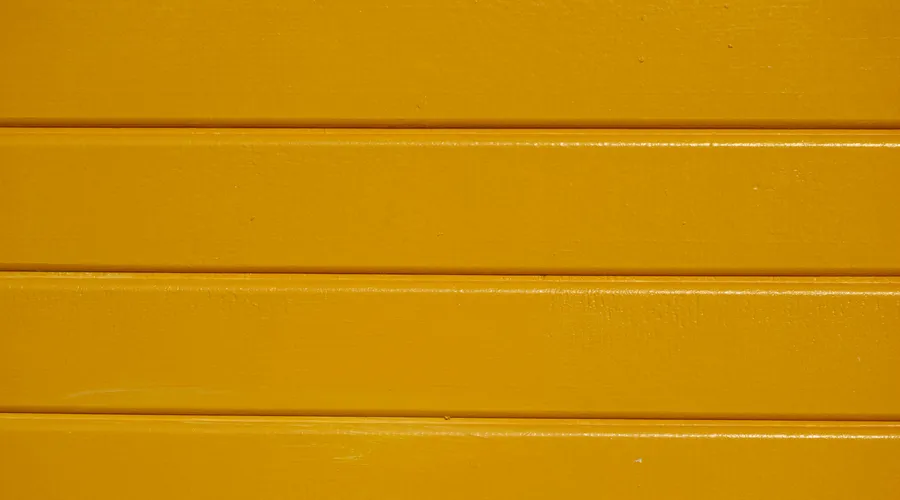 1. Benjamin Moore - Close-up of yellow painted wooden planks with a clear textured finish