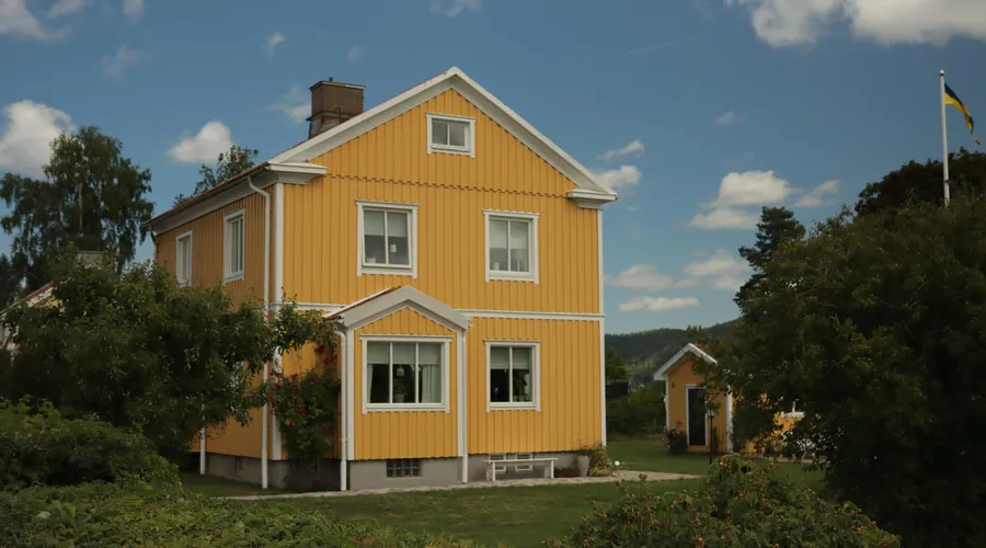 3. Behr - A vibrant yellow house in the scenic countryside of Jönköping