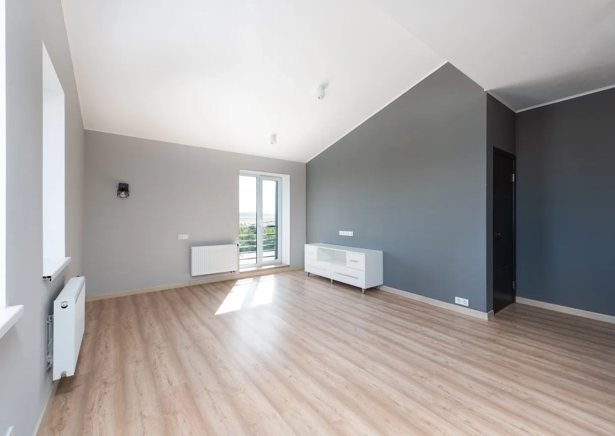 Wide-angle shot of a modern unfurnished apartment with wooden flooring and large windows in Denver
