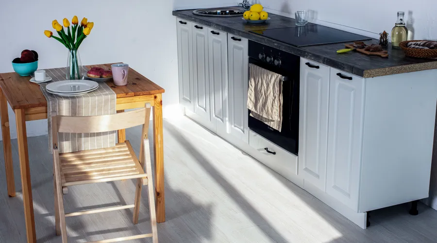 How Lighting Affects Green Cabinet Paint - A bright and cozy kitchen featuring wooden furniture and kitchen essentials