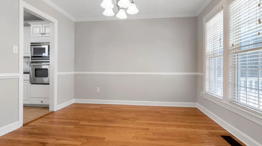 What Is Acrylic Latex Caulk? - Spacious empty room with hardwood floors and white walls