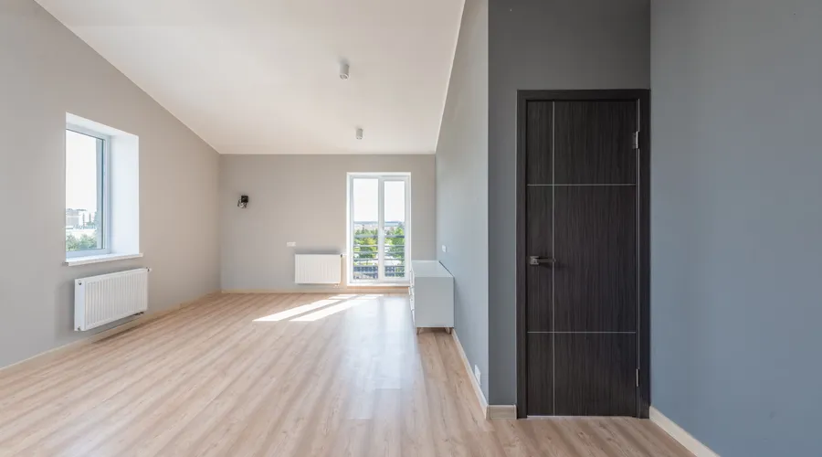 What Is Water-Based Acrylic Enamel? - Spacious empty room with wooden flooring and large windows for ample natural light