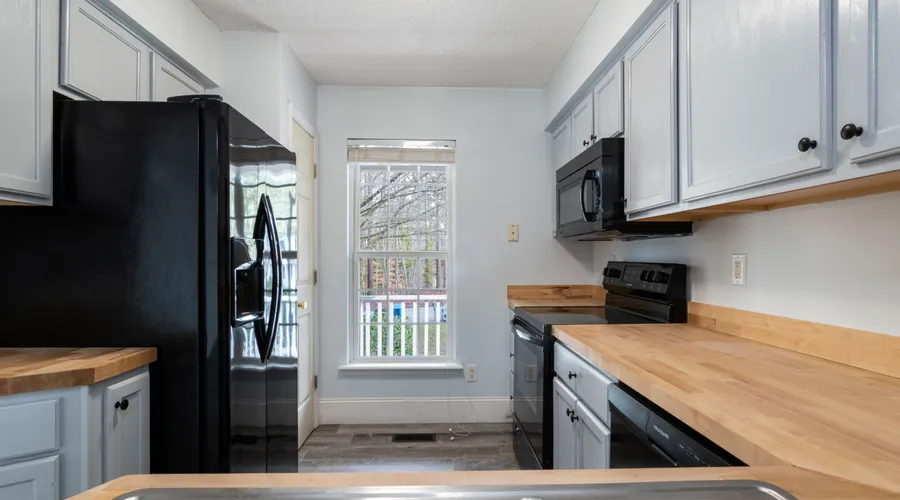 2. Sherwin-Williams Emerald - Bright and spacious kitchen featuring modern design with wooden countertops and stainless steel appliances