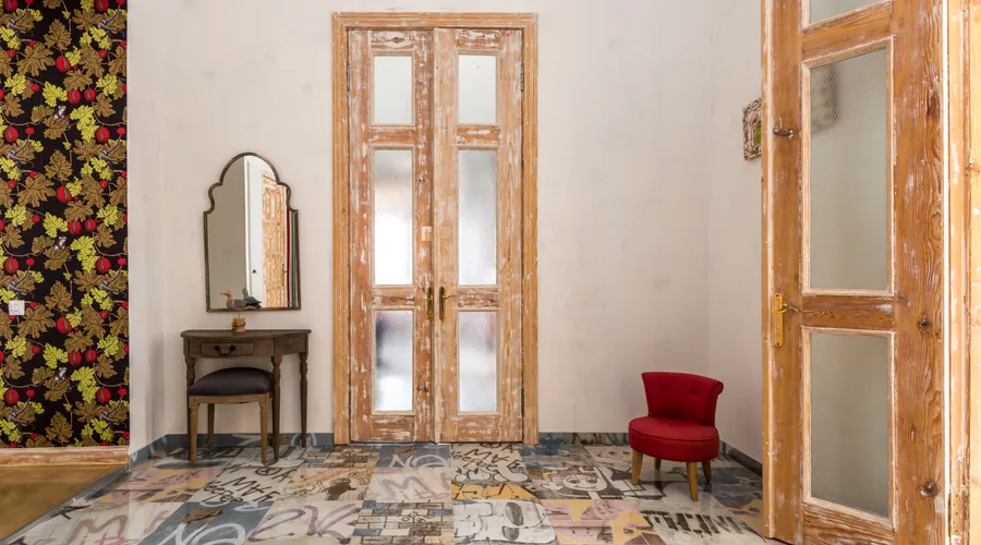 What Is Peel and Stick Wallpaper? - Charming vintage room with distressed wooden doors and graphic patterned floor
