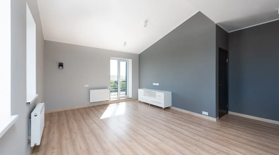 Quick Brand Comparison - Wide-angle shot of a modern unfurnished apartment with wooden flooring and large windows