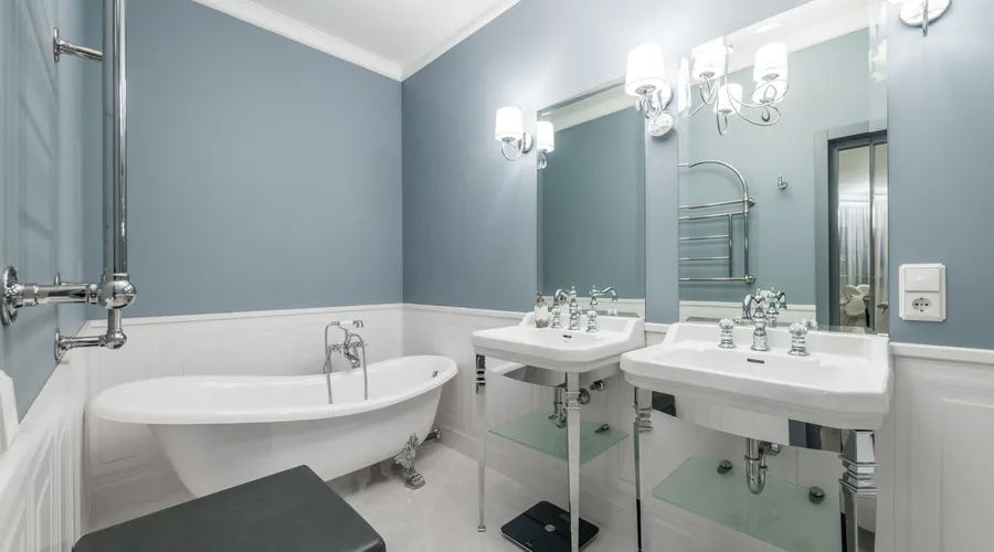 Semi-Gloss Finish - White bathtub placed near sinks under mirrors in light stylish bathroom in contemporary apartment