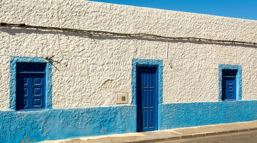 Quick Comparison - A bright blue and white urban house facade under a clear sky